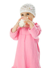 pretty little girl is holding a glass of milk