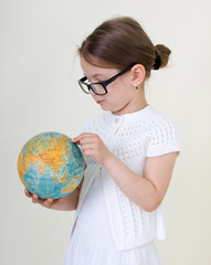 The little girl studying a globe.