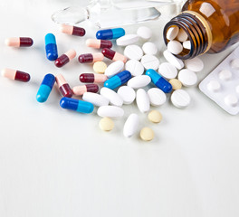 Pills pouring out of the brown bottle