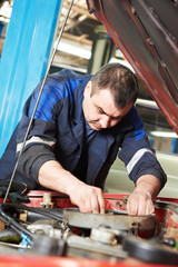 auto mechanic at car engine repair work