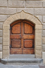 Wooden gate and a stone wall, buildings Tuscany