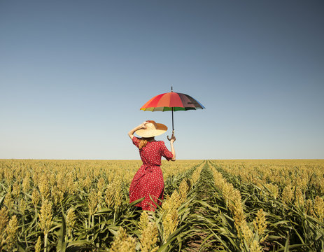 Girl with umbrella at corn field