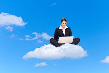 Young business woman with laptop, sitting on a cloud