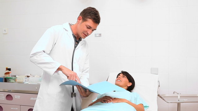 Doctor looking at a folder next to a patient