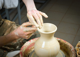 hands of a potter, creating an earthen jar on the circle
