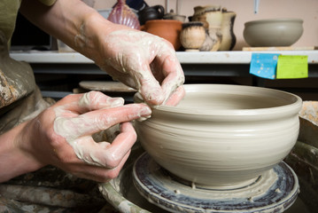 hands of a potter, creating an earthen jar on the circle