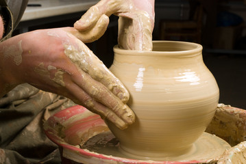 hands of a potter, creating an earthen jar on the circle