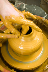 hands of a potter, creating an earthen jar on the circle