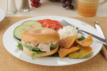 Tuna sandwich on a bagel with tortilla chips