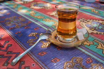 Glass of turkish tea  with sugar and spoon on the table in Istanbul city