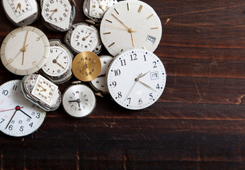 An assortment of wrist watch faces on a wood background