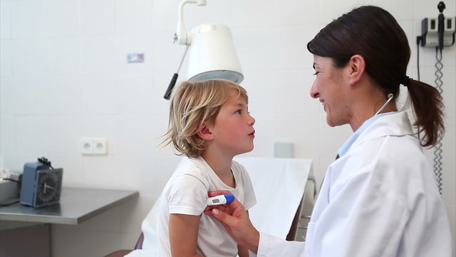 Doctor taking temperature of a child
