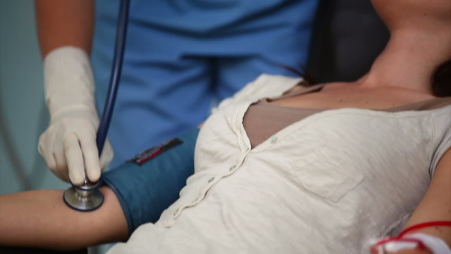 Nurse checking pulse of a donor