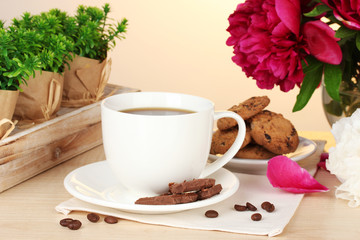 cup of coffee, cookies, chocolate and flowers on table in cafe