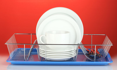 clean dishes on stand on red background