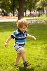 happy little boy running in garden with mouth open