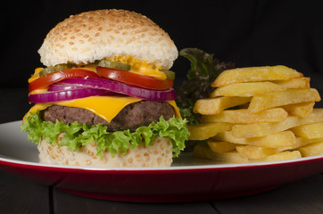 Gourmet Cheeseburger & Chips on a black background