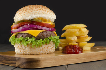 Cheeseburger & Stack of Chips and ketchup on a black background