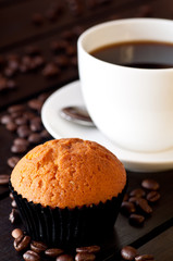 Coffee with a muffin on table close up