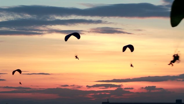 Group of paraglider or paramotor activity fly with sunset