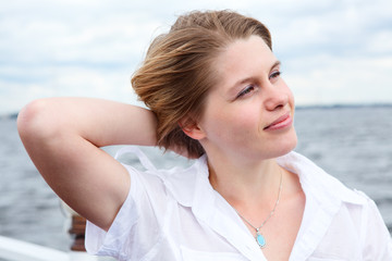 Attractive woman in white shirt standing on wind