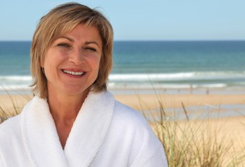 Woman with a bathrobe on the beach