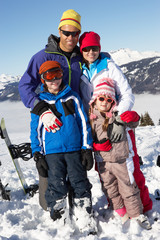 Fototapeta na wymiar Family On Ski Holiday In Mountains