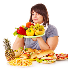 Woman choosing between fruit and hamburger.
