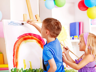 Child painting at easel.