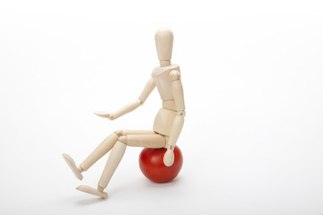 Wooden mannequin and red tomato