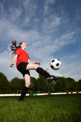Fototapeta premium Frau beim Fußball hochhalten
