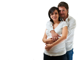 Fototapeta premium Young pregnant couple hugging over white background