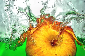  Gele appel die zich in groen water met splash-drops close-up beweegt © xixstock
