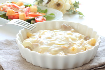 Meat and Macaroni Gratin with salad on background