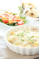 Meat and Macaroni Gratin with salad on background