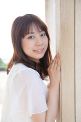 柱に寄りかかる若い女性