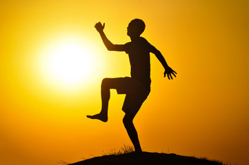 Fototapeta na wymiar Man in the sunset jump and shout