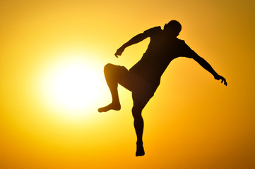 Fototapeta na wymiar Man in the sunset jump and shout