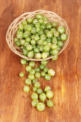 Green gooseberry in basket on wooden background