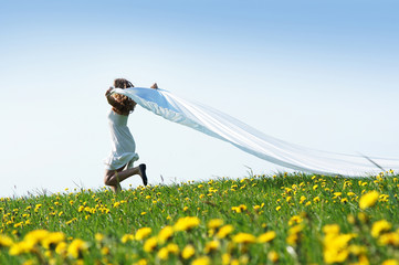 A young and beautiful girl running in a flowerish meadow