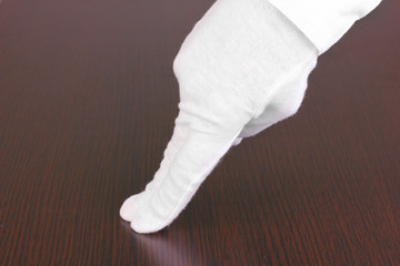 Female hand checking cleanliness on wooden background