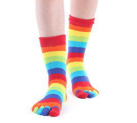 female legs in colorful striped socks isolated on white