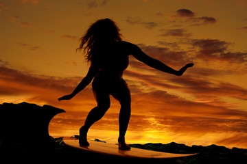 Woman surfing sunset