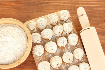 Raw Dumplings on cutting board on wooden background close-up