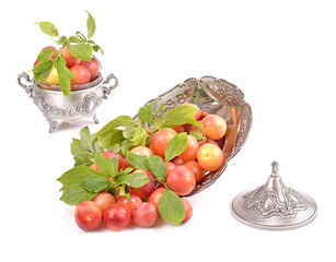 Fresh delicious plums in a metal container  isolated