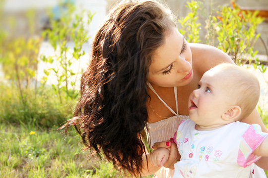 mother kissing her dear baby, outdoors portrait