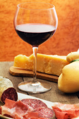selection of cheese and ham with glass of red wine