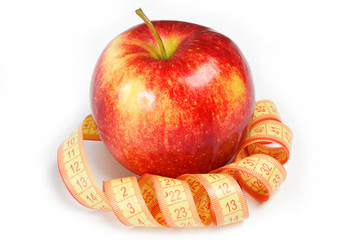 Red apple and measuring tape on a white background.