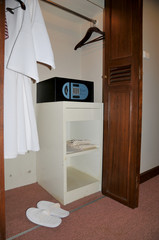 bathrobe, slippers and safe in wardrobe at hotel