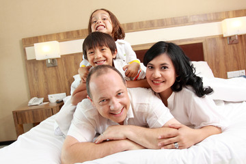 happy family on white bed